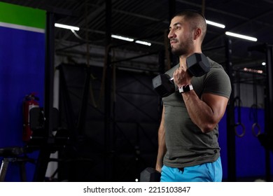 Latino Man With Sportswear Doing Biceps Exercises With Two Dumbbells In A Gym