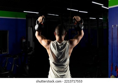 Latino Man With Sportswear, Doing Press With A Pair Of Kettlebells In A Gym