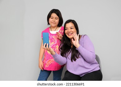 Latino Mom And Daughter Play, Dance, Surprise, Enjoy, Taking Selfies Using The Cell Phone Spending Quality Family Time