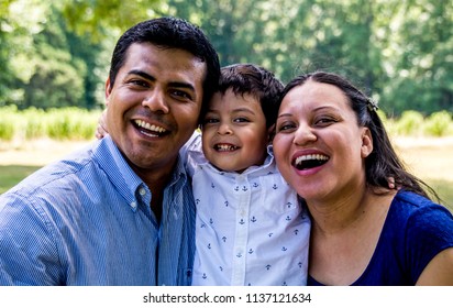 Latino parents with their son, smiling and laughing