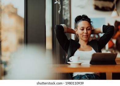 A Latino Woman Sitting In A Cafe On A Break From Work