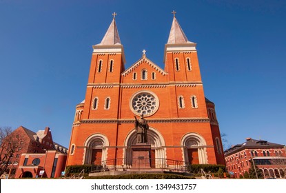 Latrobe, Pennsylvania, USA 3/23/2019 St Vincent Basilica, A Catholic Church On The Campus Of St Vincent College With A Bronze Statue Of St Vincent In Front Of It