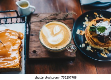 Latte Art Coffee Leaf Texture With Pancake And Bread Dessert On Wood Table In Vintage Cafe Latte Art Coffee Leaf Texture With Pancake And Bread Dessert On Wood Table In Vintage Cafe