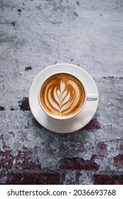 Latte art coffee on wooden table in coffee shop