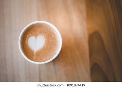 Latte Art Heart In A Paper Cup For Take Away On Wooden Table. For Who Love To Drink Coffee Everyday For Fresh In The Morning. Copy Space For Text. Top View.