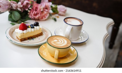 Latte Art Hot Coffee With Tulip Milk Latte Art On Top Of White Ceramic Glass Set On Table In Coffee Shop Hot Chocolate Drink With White Foam On Top In Short Cup With New York Cake As Dessert Menu.