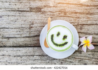 Latte Art With Japanese Green Tea Matcha With Artistic Cream Smile Face Decoration On Old Cement Wall Background