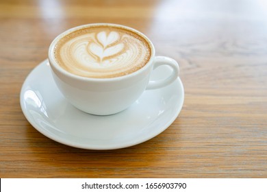 Latte Art In A White Coffee Mug On A Wooden Table