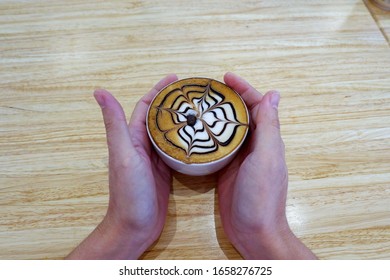 Latte coffee between both hands