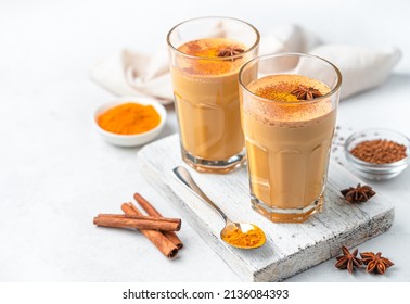 Latte with turmeric and cinnamon on a white background. A drink that increases immunity. Side view, copy space.