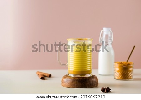 Latte turmeric on a pink background. Moon milk for better sleep. Ayurvedic drink. Copy space.