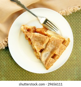 Lattice Top Apple Pie Slice With Fork On A Green Dotted Background.