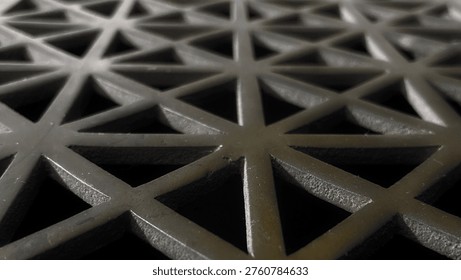 The latticework of a grate; a closeup