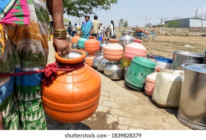 Latur, Maharashtra, India/April 07, 2016: Due to severe water scarcity, local residents fill water in huge plastic containers from a water tanker in Latur district, Maharashtra. India