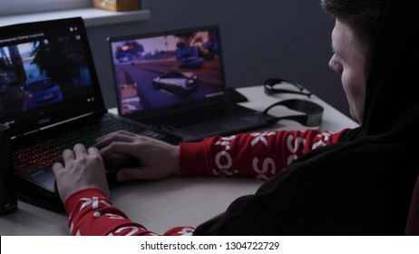 Latvia, Jurmala - 11 January 2019:A young guy (male) player plays a professional player on the GTA tournament on two laptops. Concept of: New games, Gambling addiction, Dependence, GTA, Racing. 