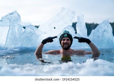 Latvia. Kadaga Lake. January 10, 2021. Young Man Taking An Ice Bath. Swimming In A Frozen Lake During Winter. Healthy Cold Swim.