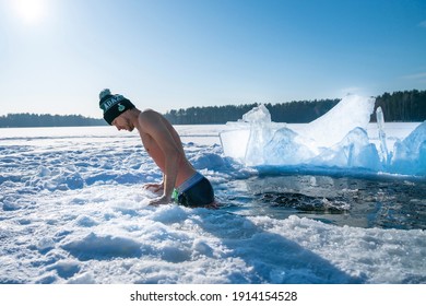 Latvia. Kadaga lake. January 10, 2021. Young man taking an ice bath. Swimming in a frozen lake during winter. Healthy cold swim.