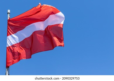 Latvian national flag waving on blue sky background. Republic of Latvia, CY - Shutterstock ID 2090329753