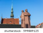 Latvian Riflemen monument, Old Town of Riga, Latvia. View with spire of St Peter