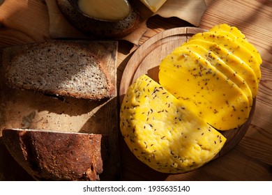 Latvian traditional St.John's day cumin or caraway cheese sliced in slices, Latvian goods is on the table: bread, honey, butter