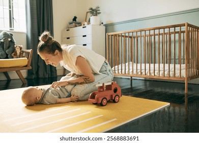 Laugh, bond and mother and baby playing in nursery, have fun and enjoy relax time together at home. Happy family love, growth and newborn child care of youth kid with mom tickling infant on floor