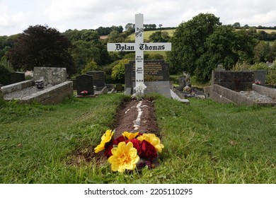 Laugharne Wales September 2022. The Grave Of The Welsh Poet, Writer Dylan Marlais Thomas In The Graveyard Of St Martin's Church. Born 27 October 1914, Died 9 November 1953. Simple White Wooden Cross. 