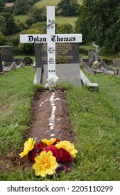 Laugharne Wales September 2022. The Grave Of The Welsh Poet, Writer Dylan Marlais Thomas In The Graveyard Of St Martin's Church. Born 27 October 1914, Died 9 November 1953. Simple White Wooden Cross. 