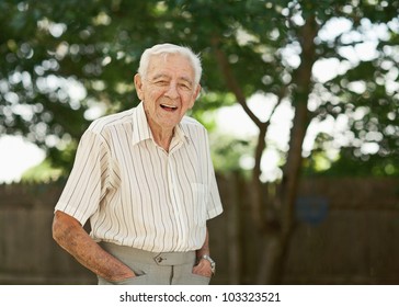 Laughing 90 year old senior man standing outside