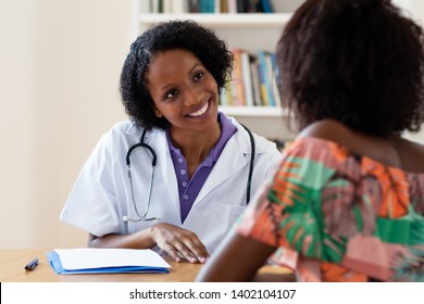 Laughing african american female doctor with patient at hospital