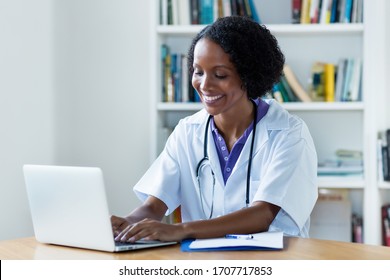 Laughing african american female medical scientist researching for vaccines against coronavirus at hospital