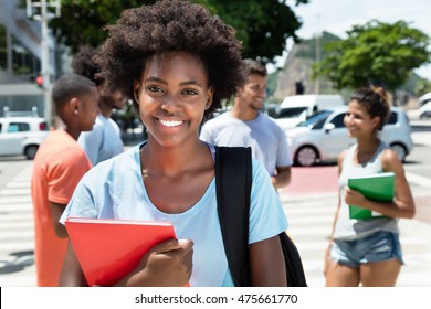Laughing african american female student with group of friends