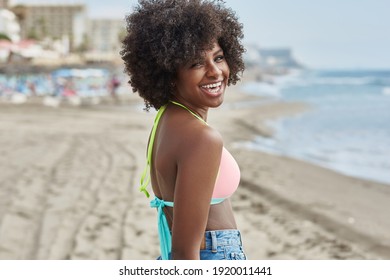 Lachen über Amerikanerin in Bikini am Strand