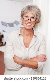 Laughing Attractive Senior Woman Wearing Glasses Standing With Folded Arms