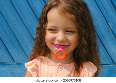Laughing Baby With Mouthguard In Mouth For Bite Alignment. Crooked Uneven Teeth In A Child. A Cute Three - Year - Old Girl With A Vestibular Hard Mouth Guard Plate For Correcting The Bite Of Teeth