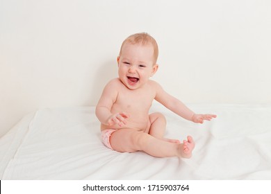 Laughing Baby Only In Panties Sits On A White Background