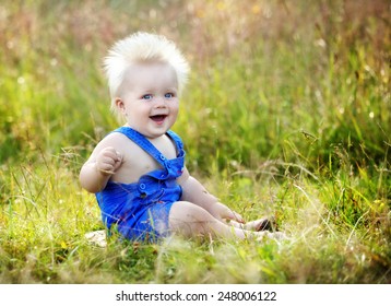 Laughing baby sitting in the grass