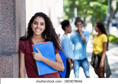 Laughing Brazilian Female Student With Group Of Young Adults Outdoor In City In Summer