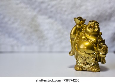 Laughing Buddha. God of Hotei. Gold figurine. Buddhism.