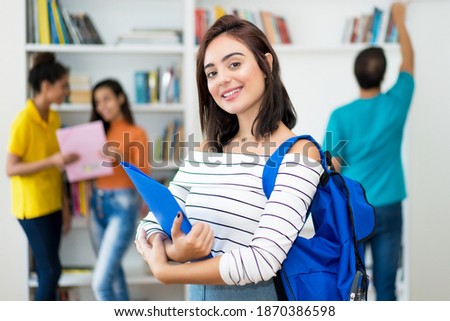 Laughing caucasian female student with group of students at classroom of university