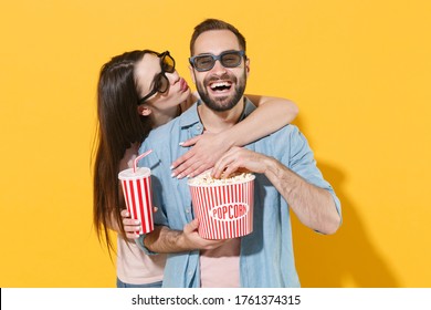 Laughing Couple Two Friends Guy Girl In 3d Glasses Isolated On Yellow Background. People In Cinema Lifestyle Concept. Watching Movie Film Holding Bucket Of Popcorn Cup Of Soda, Hugging, Kiss In Cheek