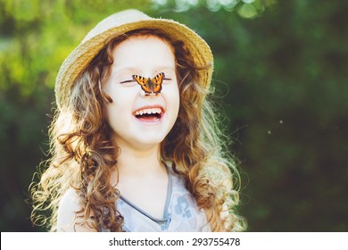 Laughing curly girl with a butterfly on his hand. Happy childhood concept. Background toning for instagram filter. - Powered by Shutterstock