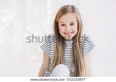 Laughing cute girl portrait at home. Little child smiling and looking at camera
