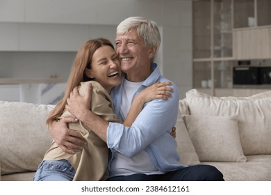 Laughing excited woman cuddle older father, loving multigenerational family enjoy reunion after long separation, hoary man hugs his grown up daughter visited him at home, feeling unconditional love - Powered by Shutterstock