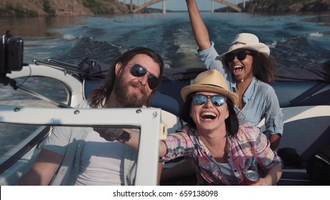 Laughing Family Or Three Friends Wearing Sunglasses Riding In A Speedboat On A Lake Or River As They Celebrate Their Summer Vacation Viewed Close Up