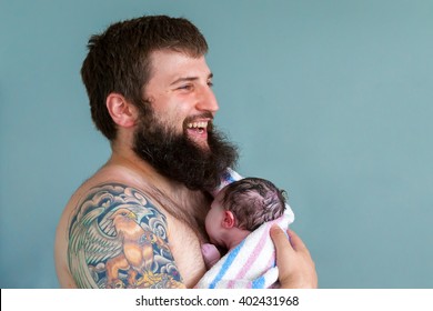 A Laughing Father Holds His Newborn Son Close To His Chest For Skin On Skin Bonding Contact.  The Baby Seems To Be Trying To Nurse.  There Is Plenty Of Room For Copy.