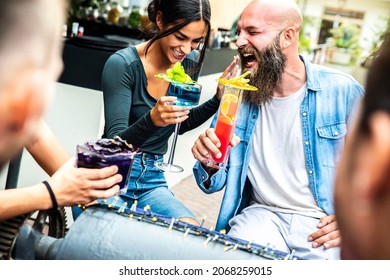 Laughing Friends Cheering Drinks At Lounge Bar Restaurant - Diverse Young  People Having Party Drinking Cocktails Outdoors - Funny Multiracial Couple Smiling Making Joke Together Outside   