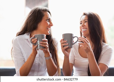 Laughing Friends Having A Coffee In A Cafe