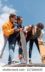laughing friends looking at asian skater grimacing and pointing with finger outdoors - Shutterstock ID 2171046535