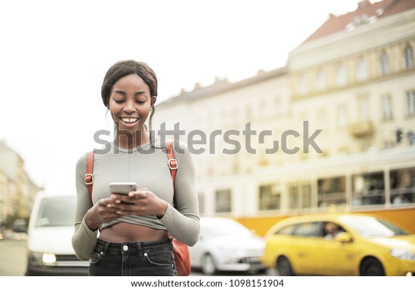 Laughing girl sending a\
text message\
