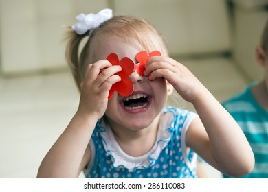 laughing girl shut her eyes red flowers of colored cardboard